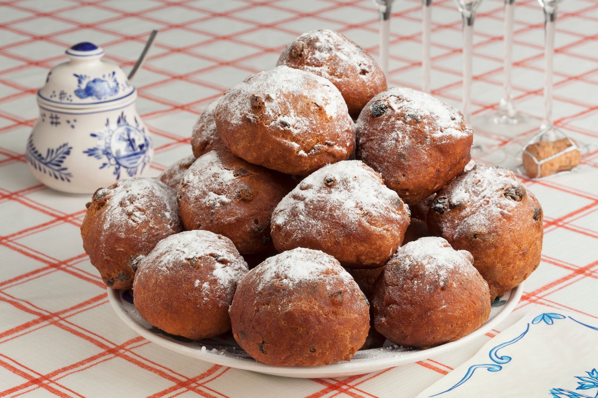 Heap of traditional sugared fried fritters or Dutch oliebollen on a dish close up for New Years evening