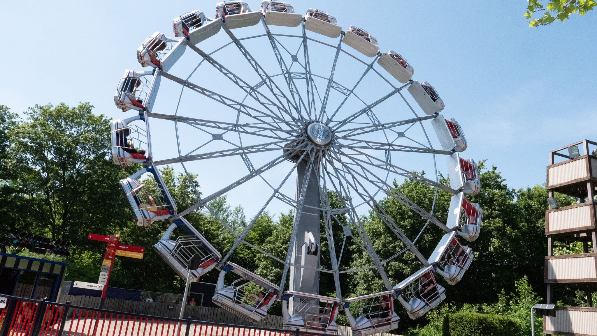 Een groep vrienden met twee jongens achterin de koets en twee meisjes voorin de koets genieten van een ritje in de ongetemde attractie bij Walibi Holland. 